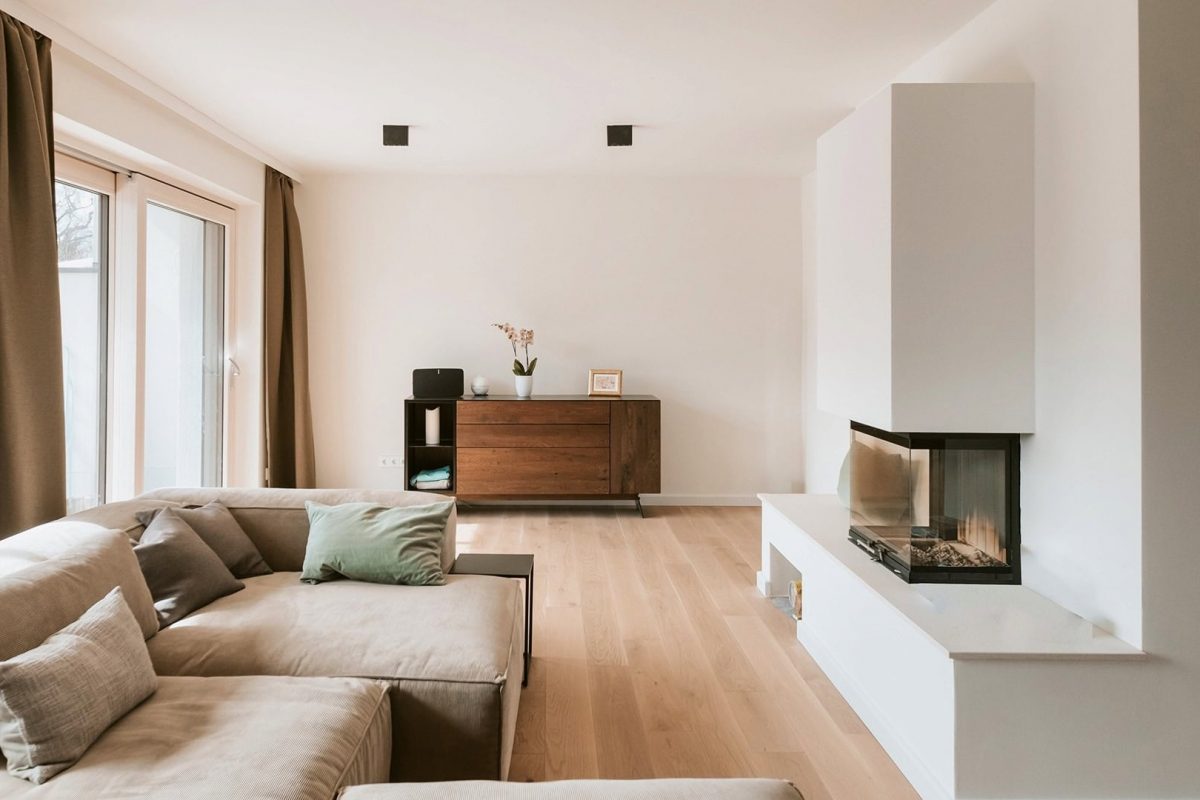 Innenarchitektur München, Büro Innenarchitektur Federleicht – Moderner Wohnbereich mit hellem Holzfußboden, gemütlichem Kamin und elegantem Sideboard