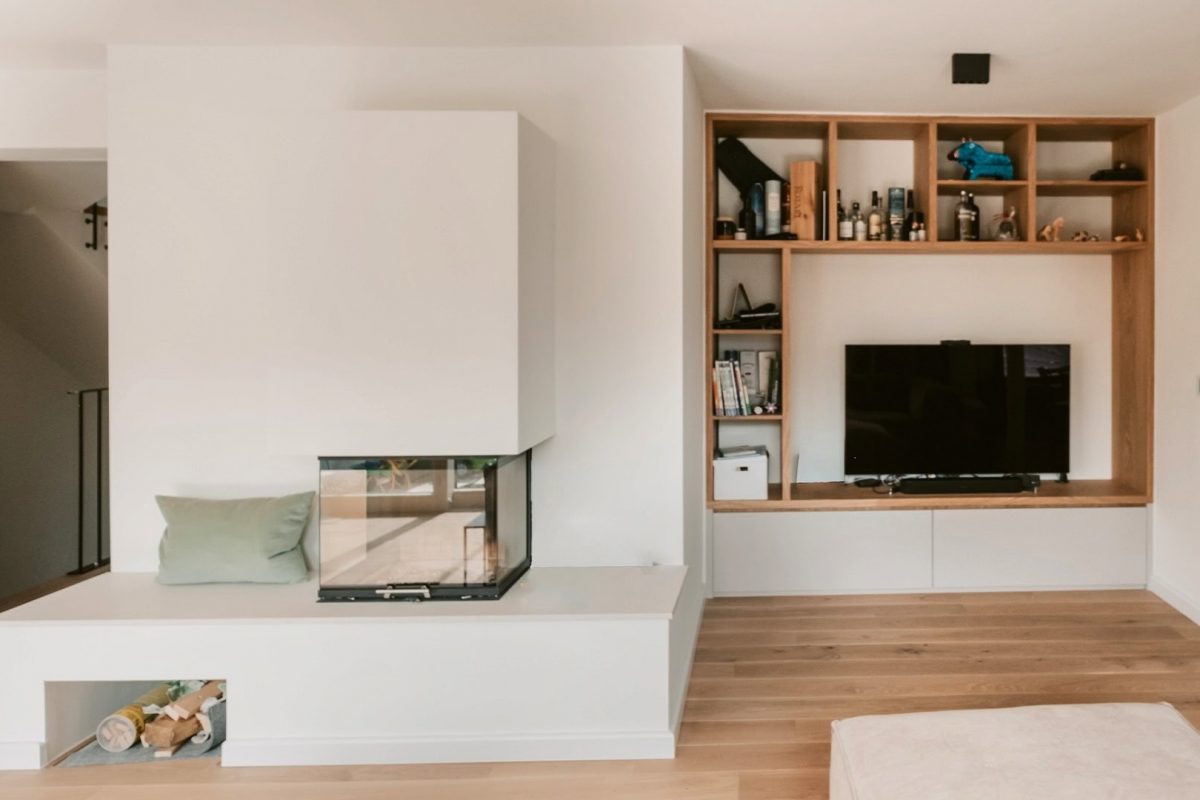 Innenarchitektur München, Büro Innenarchitektur Federleicht – Moderner Wohnbereich mit integriertem Kamin, maßgefertigtem Regal und gemütlichem Sitzbereich