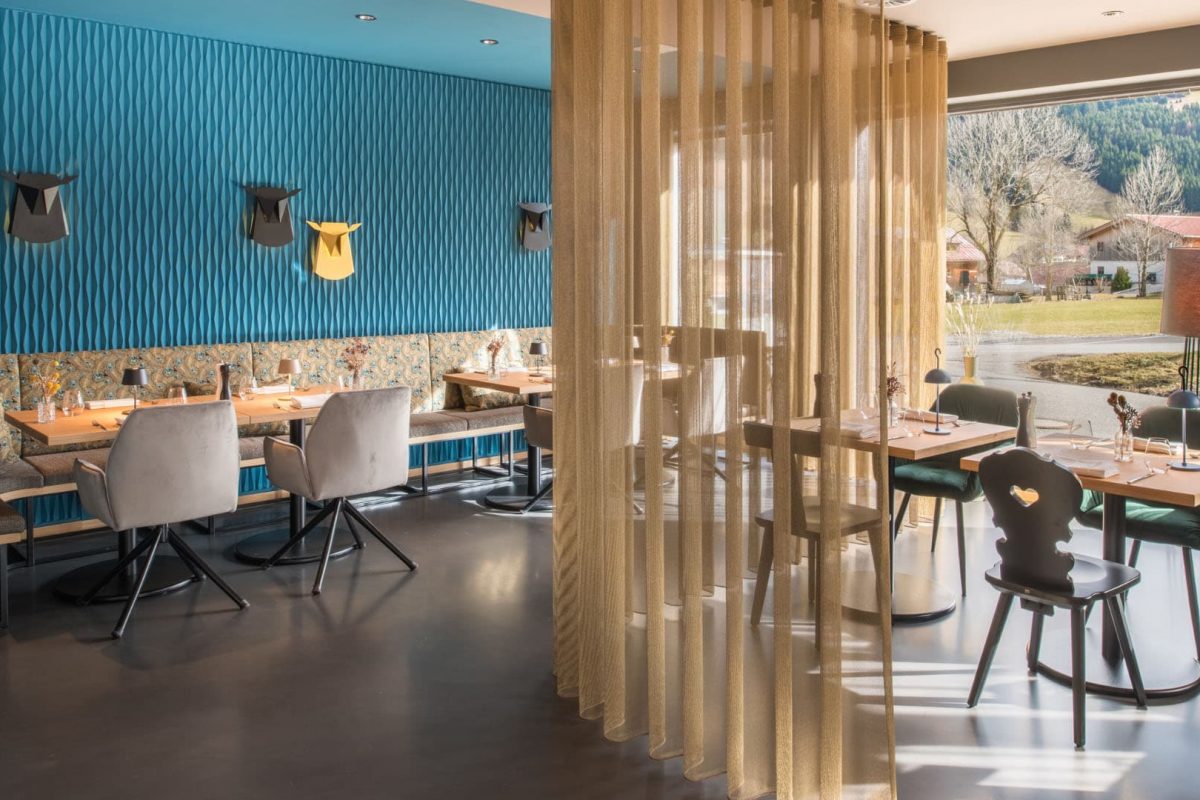 Innenarchitektur München / Innenarchitektur Federleicht - Moderner Speisesaal im La Soa Chalets mit Petrol-Akzenten, transluzenten Vorhängen und stilvoller Wandgestaltung