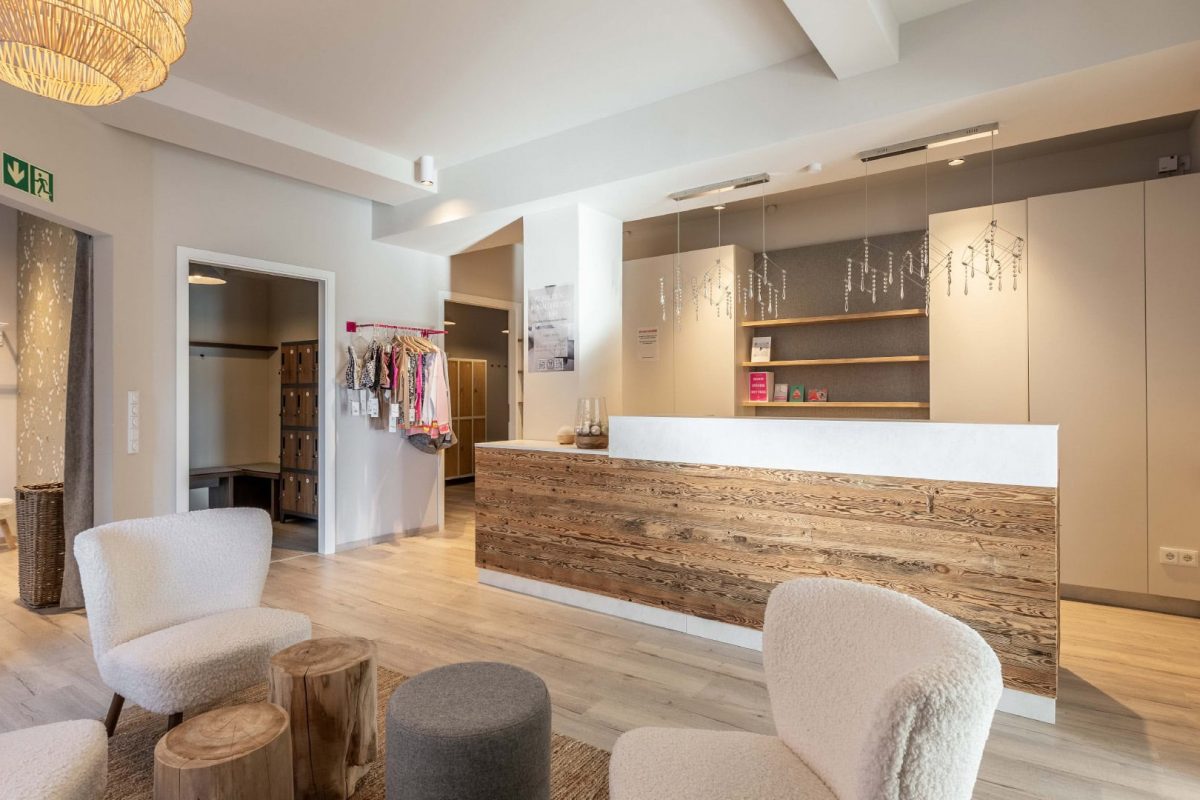 Innenarchitektur München / Innenarchitektur Federleicht - Empfangsbereich eines Yogastudios mit Holzdetails, minimalistischer Gestaltung und einladender Atmosphäre