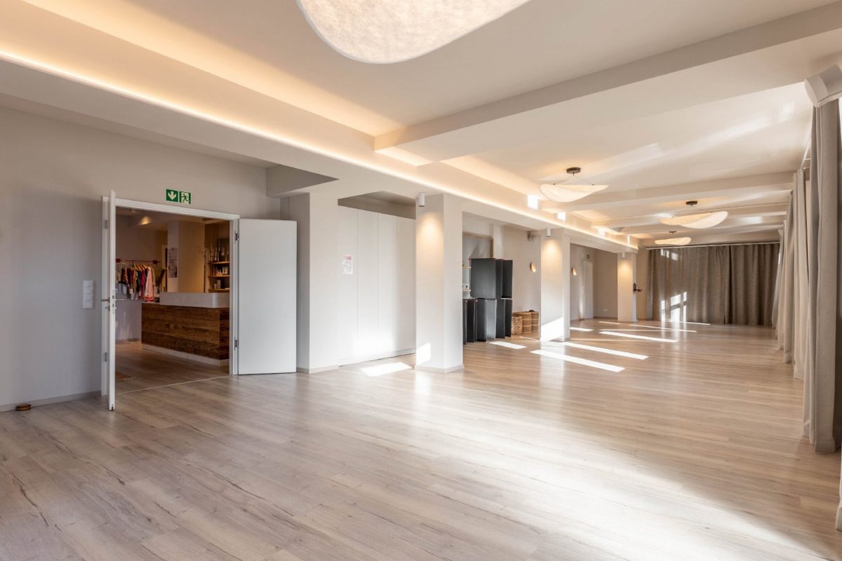 Innenarchitektur München / Innenarchitektur Federleicht - Yogaraum mit hellem Holzboden, dezenter Beleuchtung und moderner, offener Gestaltung