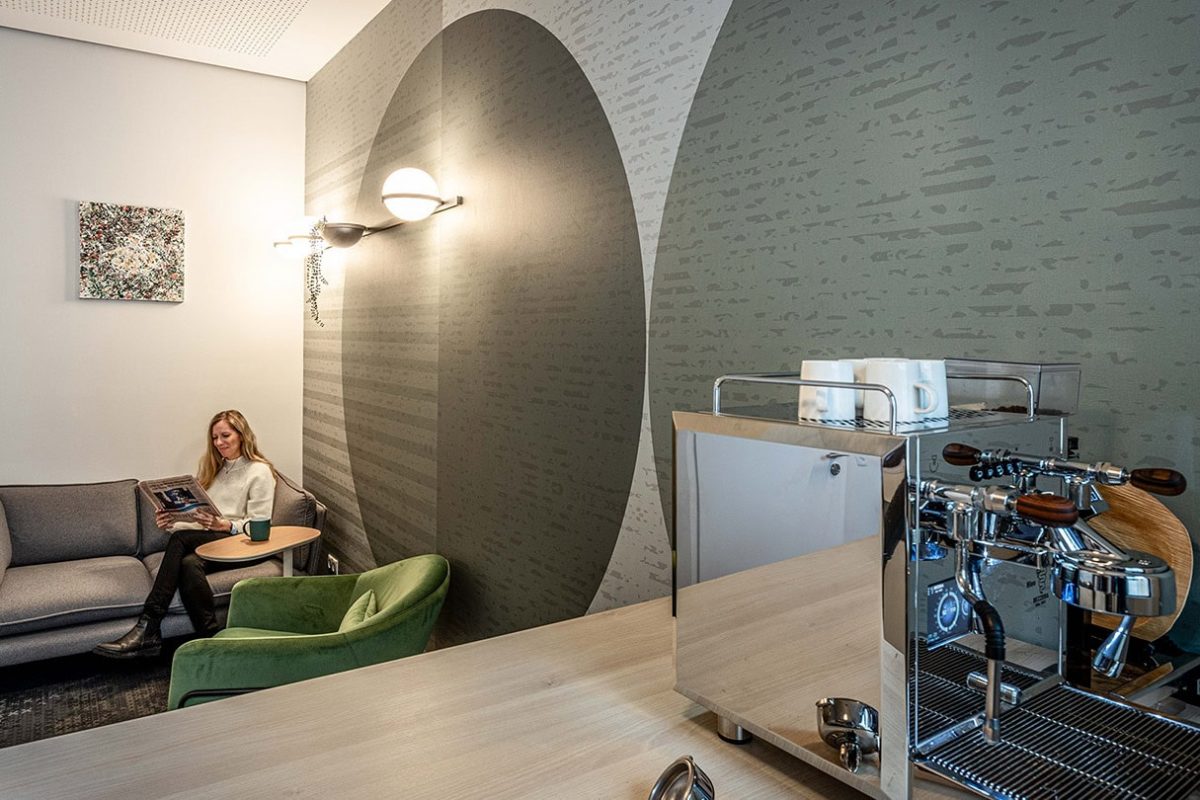 Innenarchitektur München / Innenarchitektur Federleicht - Bürogestaltung, Kaffeebar mit grüner Akzentwand und modernen Kreis-Motiven für eine inspirierende Atmosphäre beim Austausch mit Kolleg*innen